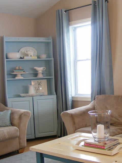 living-room-with-teal-cabinet-and-curtains