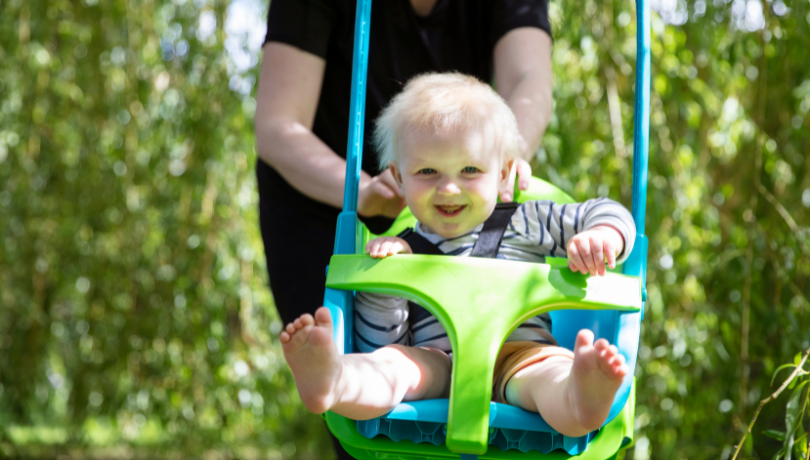 happy-baby-playing-in-a-bucket-swing
