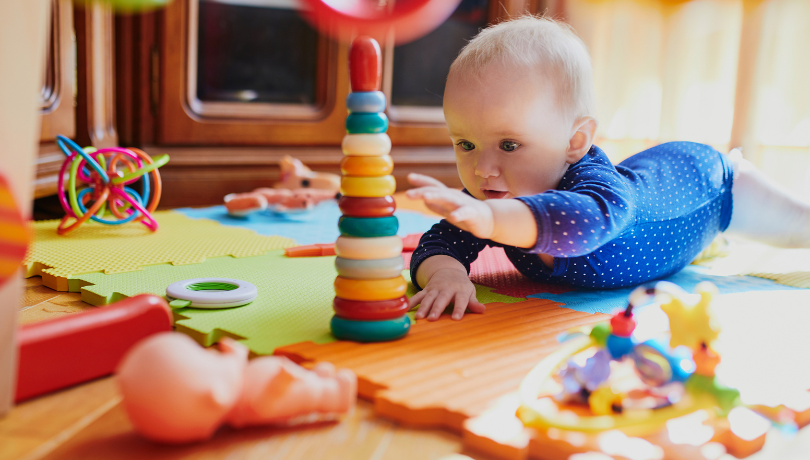 white-baby-enjoying-tummy-time-with-toys