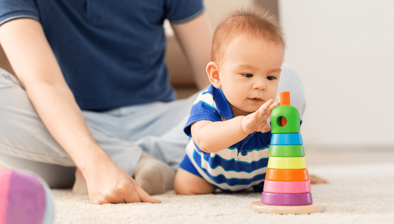 father-watching-over-baby-playing-with-toys