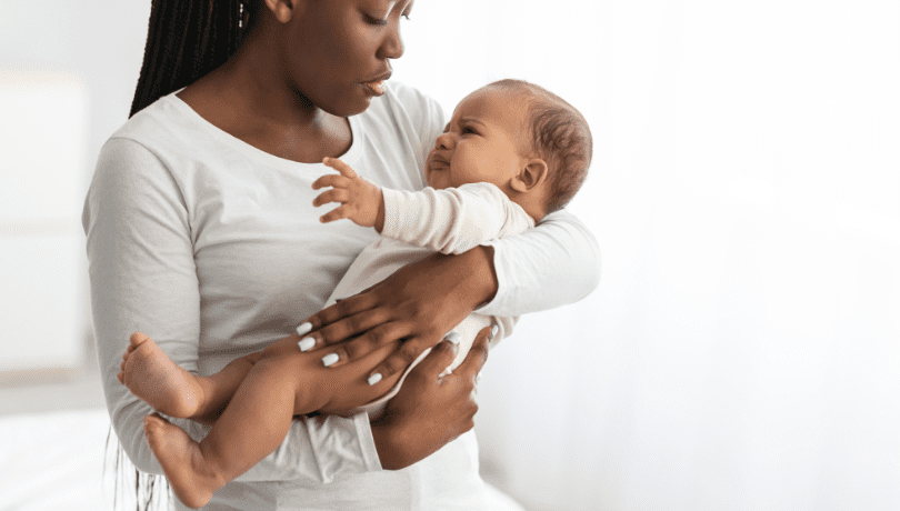 young-black-mother-soothing-a-crying-baby-in-her-arms