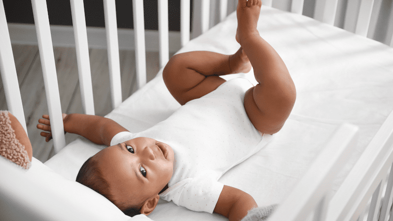 cute-baby-lying-on-a-crib-mattress