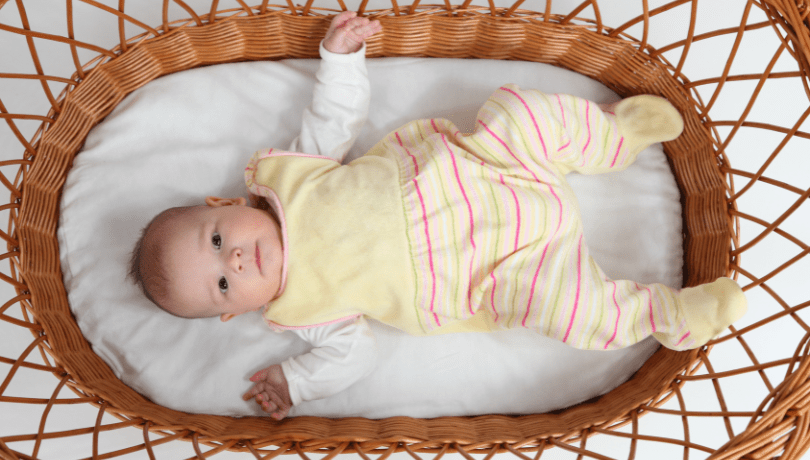 cute-white-baby-looking-up-from-a-bassinet