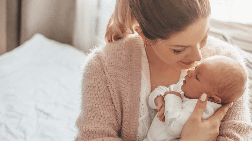 happy-white-mom-holding-newborn-baby