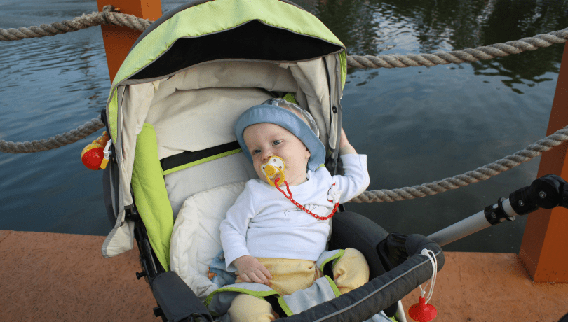 little-baby-in-their-stroller-beside-the-waterfront