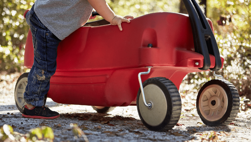 little-boy-getting-into-a-red-wagon
