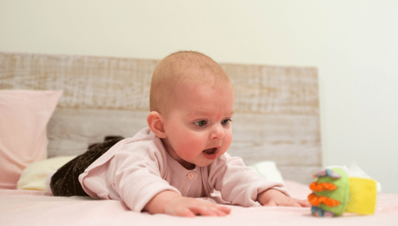 curious-white-baby-enjoying-some-tummy-time-with-a-toy