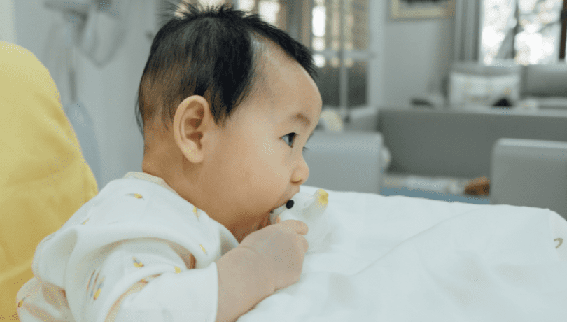 asian-baby-chewing-on-a-teething-toy