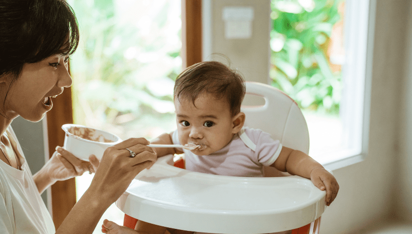 asian-mother-feeding-her-baby-at-home