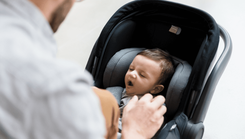 dad-fastening-yawning-baby-into-convertible-infant-car-seat