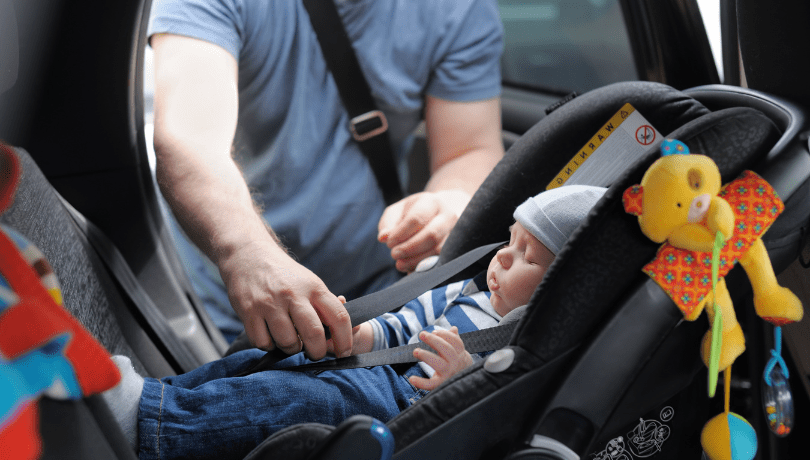 father-securing-his-baby-in-his-infant-car-seat