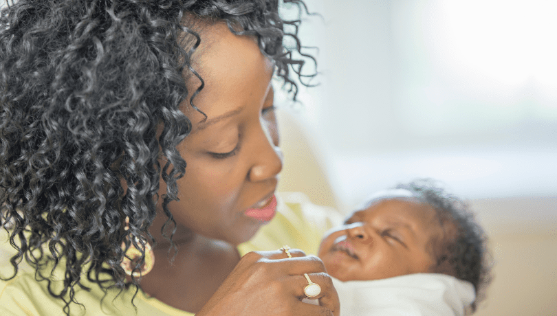 african-american-mother-gently-holding-her-swaddled-baby