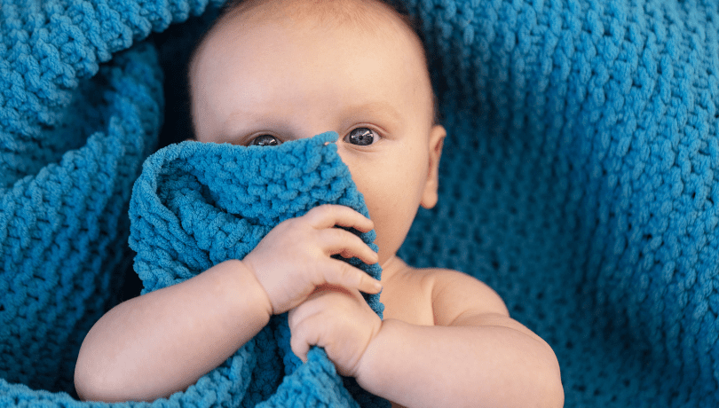 baby-boy-hugging-a-soft-blue-blanket