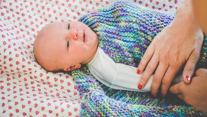 cute-white-baby-being-swaddled-by-mother