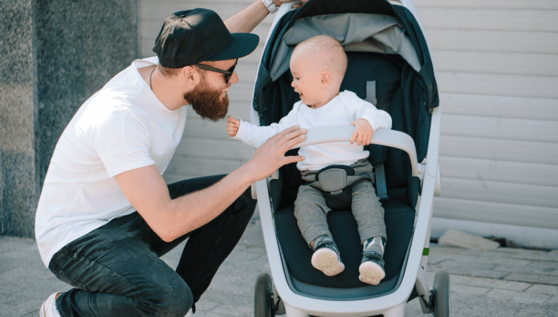 father-talking-to-baby-sitting-on-a-stroller