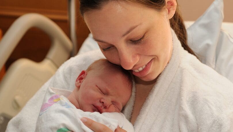 mother-holding-her-swaddled-newborn-in-the-hospital