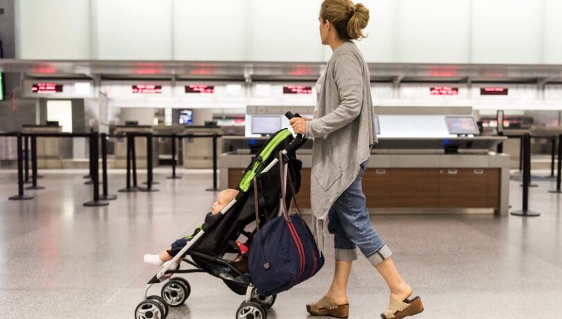 mother-pushing-a-stroller-with-her-child-at-the-airport