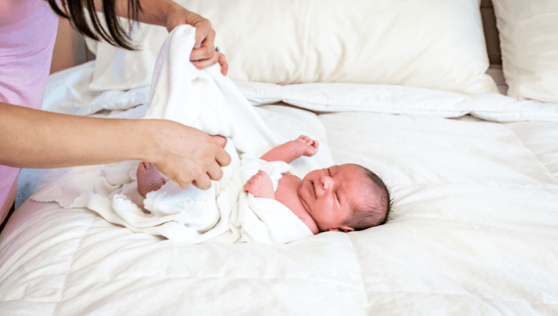 mother-swaddles-newborn-baby-at-home