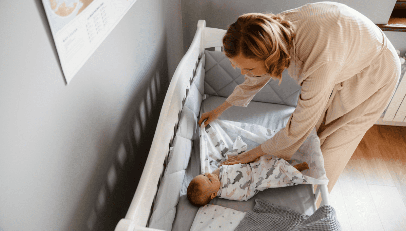 young-white-mother-swaddling-her-newborn-baby
