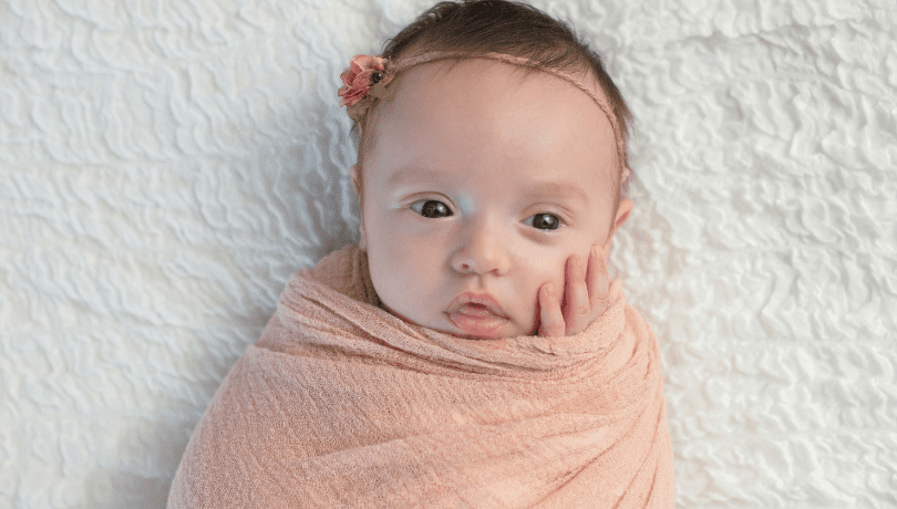 one-month-old-baby-girl-swaddled-in-a-peach-blanket